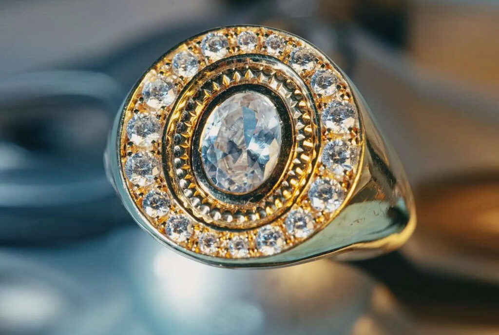 Chevalière en or jaune sertie d’un diamant ovale et d’un entourage